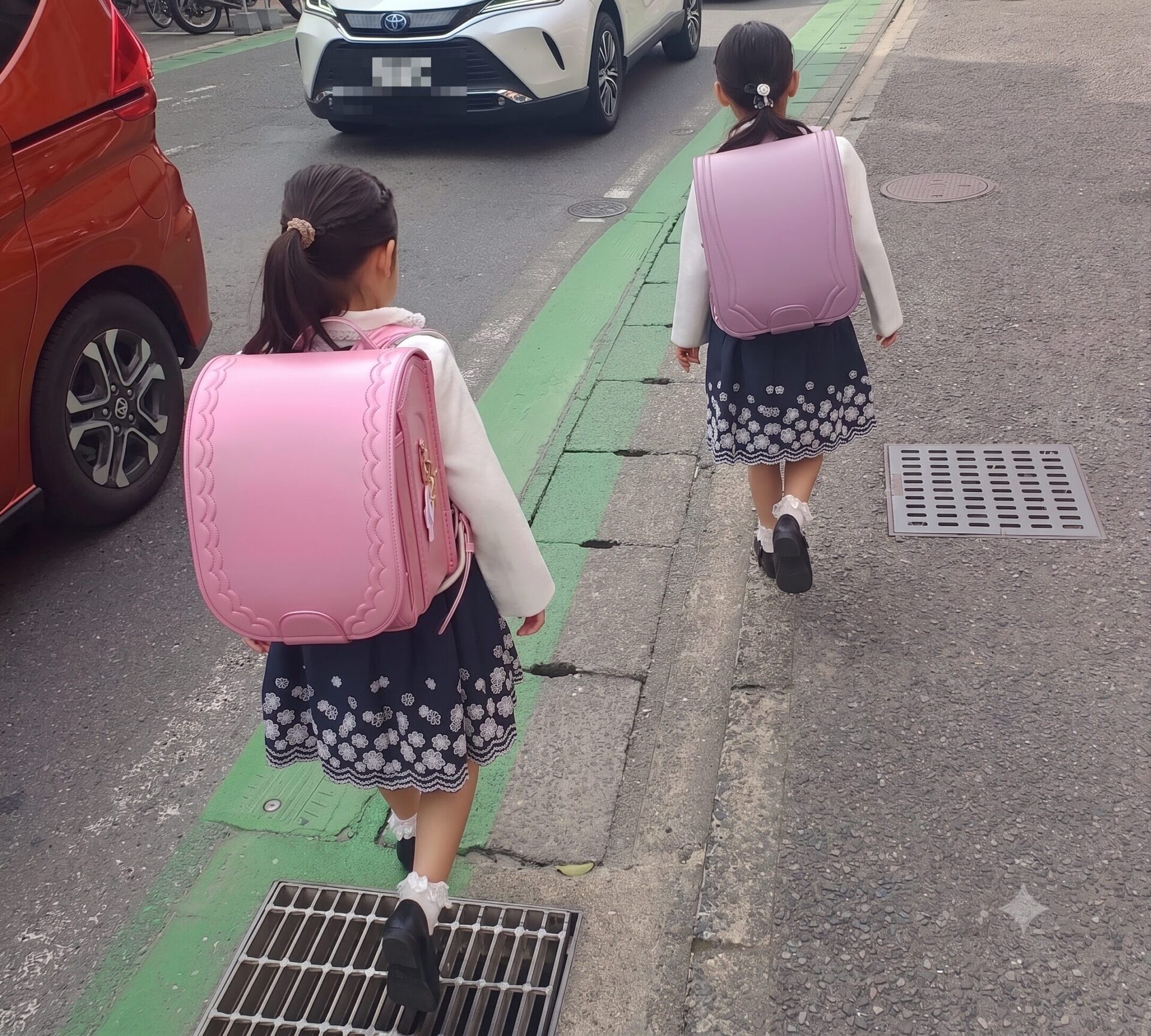 ランドセルを背負って登校する双子の娘たち