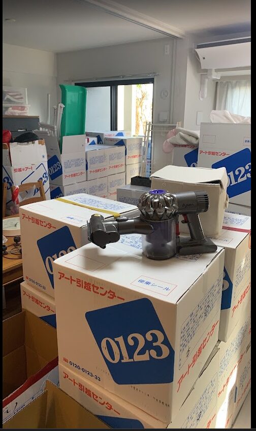 引越し当日の段ボール。アート引越センターの箱が部屋いっぱいに積まれている
